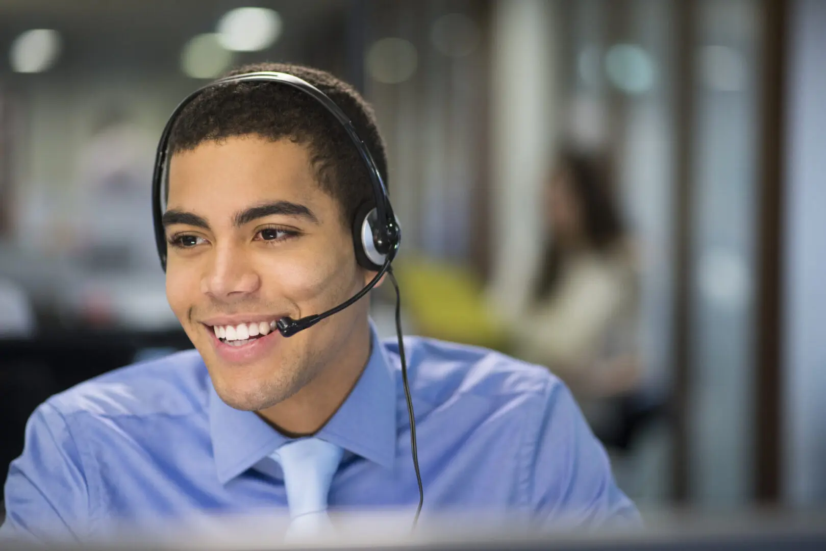 young male call centre rep in an open plan office