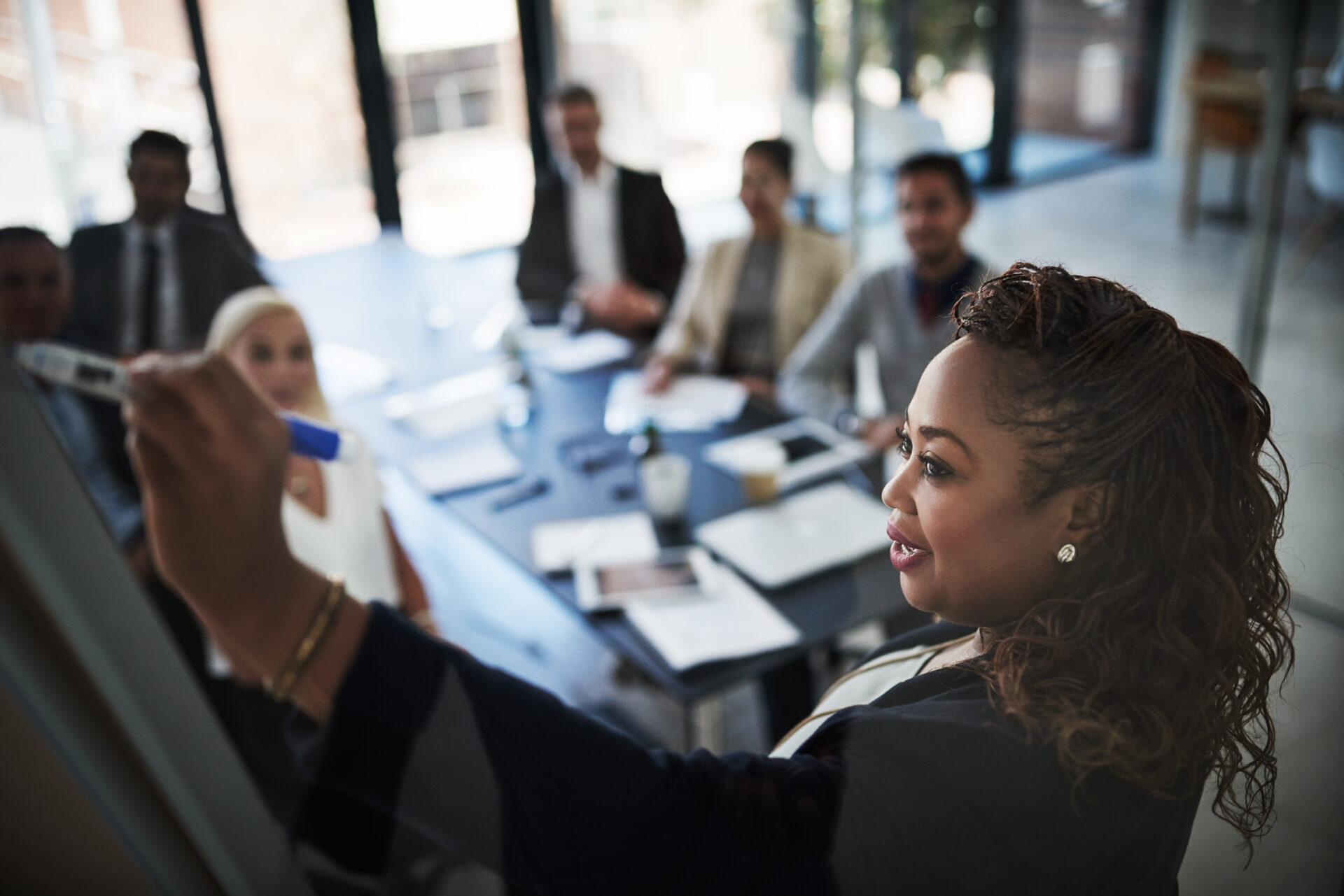 High angle shot of a young businesswoman explaining work related stuff during a presentation to work colleagues in a boardroom